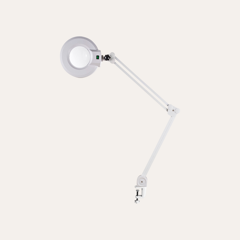White magnifying lamp with adjustable arm on a white background