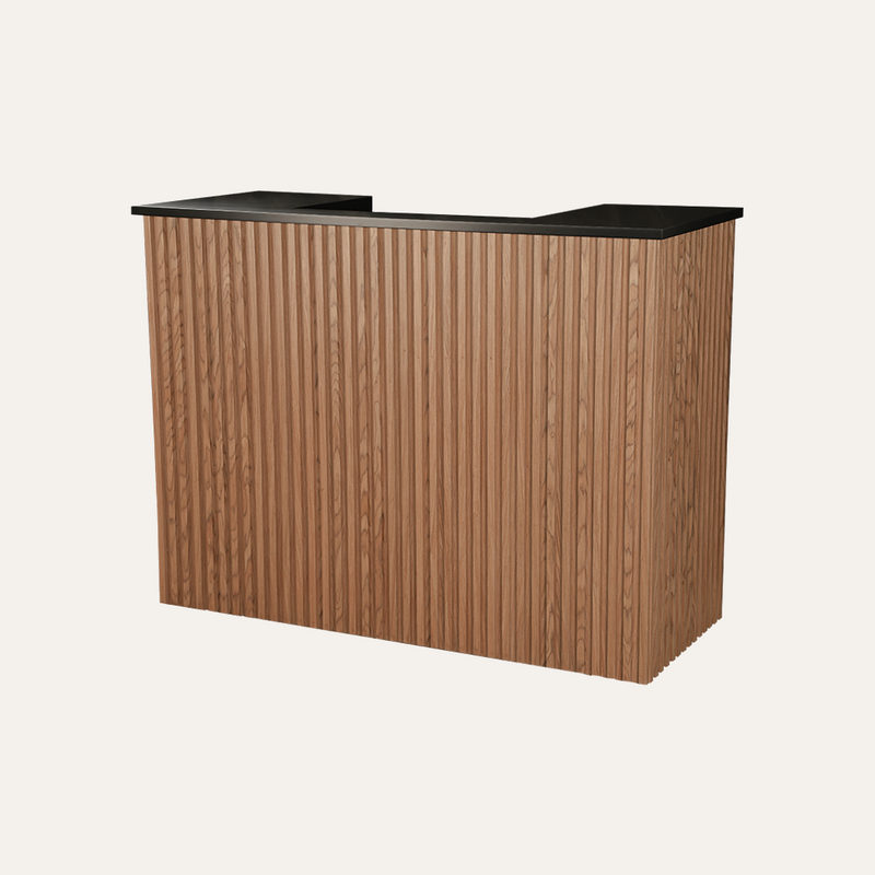 A modern Aveline reception desk with a vertical fluted wood-grain front and a black countertop